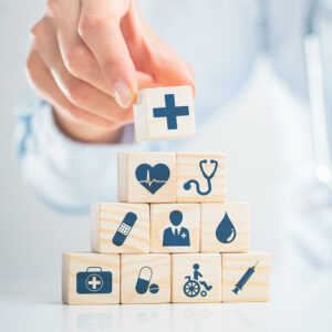 Hand arranging wood block with healthcare medical icon. Health insurance - concept.